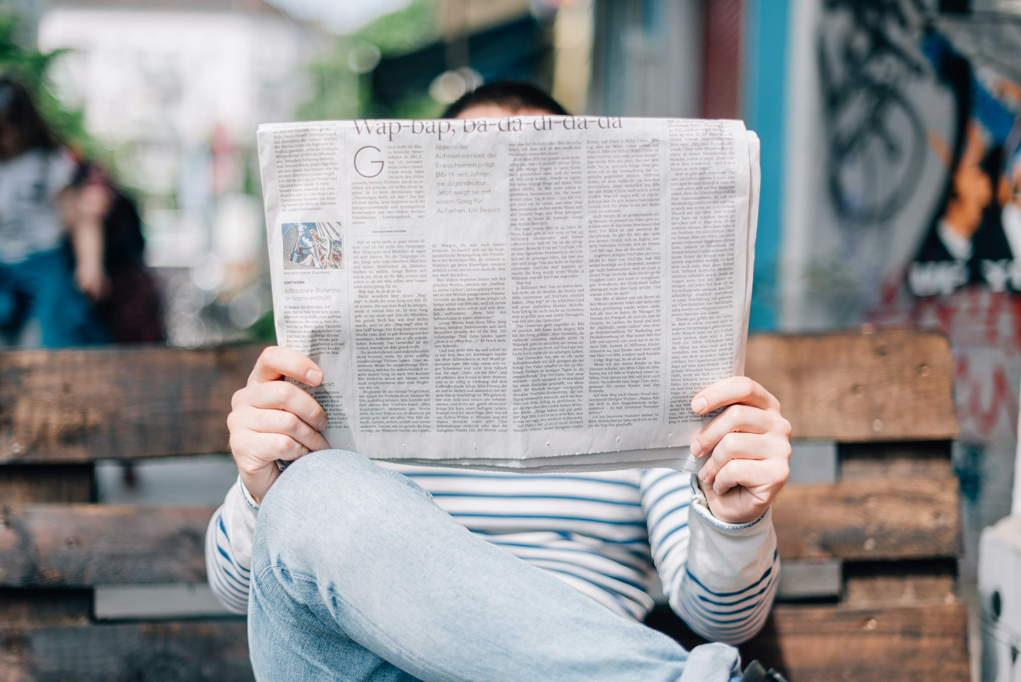 Person reading a business newspaper over coffee
